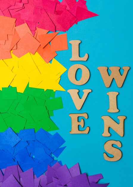 Montones de papel en colores LGBT brillantes y amor gana palabras