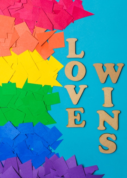 Montones de papel en colores LGBT brillantes y amor gana palabras