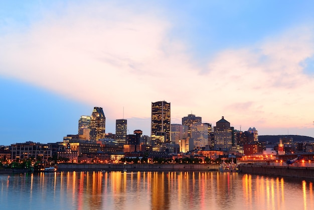 Montreal sobre el río al atardecer con luces de la ciudad y edificios urbanos
