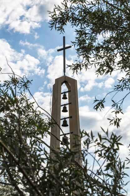 Monumento religioso con cruz y campanas