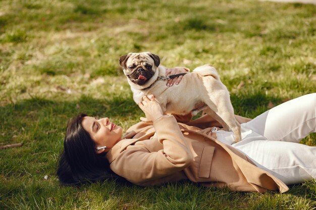 Morena con un abrigo marrón camina con pug