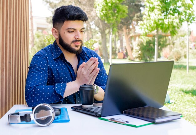 Morena asiática hombre sentado trabajando en la computadora portátil