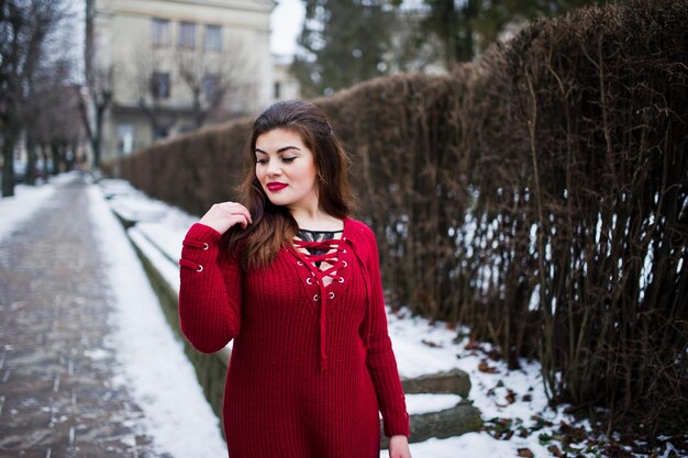 Morena modelo de talla grande en rojo en la calle de la ciudad