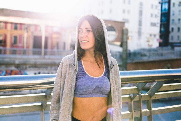 Morena, mujer, llevando, sportswear, posición, sonriente