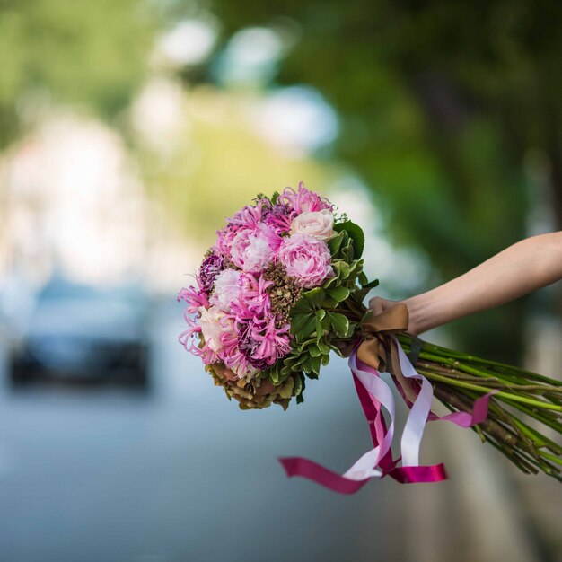 Mostrando un ramo púrpura de rosas y flores de seda en la vista de la calle