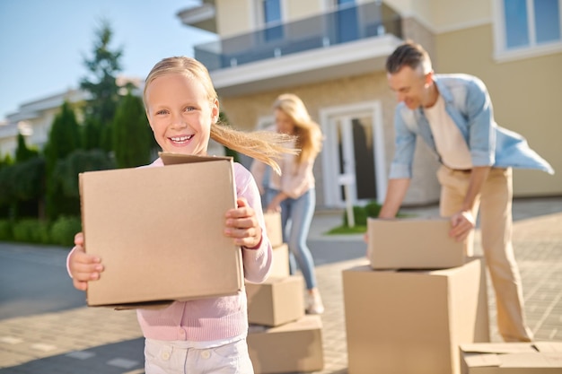 Moviente. Linda familia desembalaje de cajas de cartón mientras se muda a una nueva casa