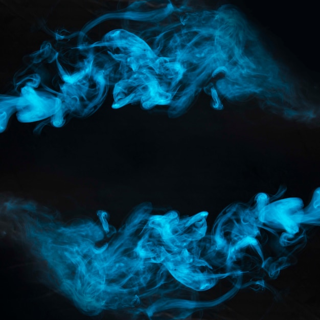 Movimiento de humo azul sobre fondo negro.