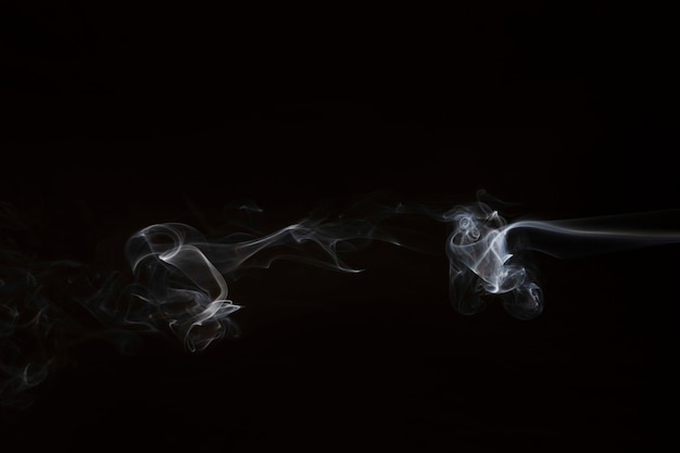 Foto gratuita movimiento de humo blanco sobre fondo negro.