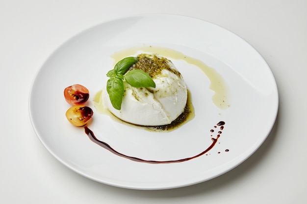 Mozarella servida con pesto, tomates cherry