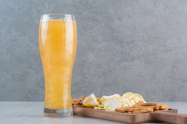 Mucha comida deliciosa a la cerveza sobre tabla de madera.