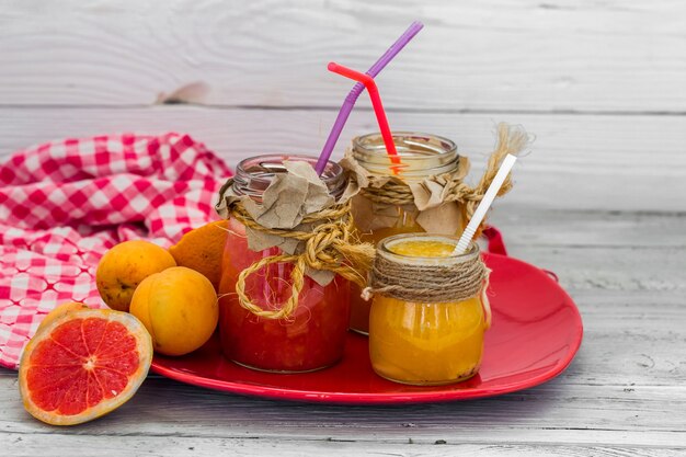 Mucha fruta fresca, cortada en un hermoso fondo de madera, bebida de fruta fresca, mermelada, comida sabrosa y saludable