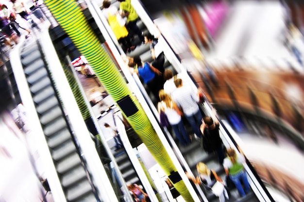 Mucha gente en la escalera mecánica