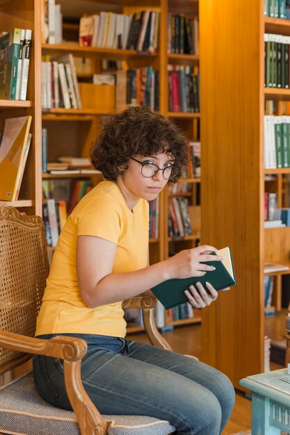 Muchacha adolescente leyendo en una bonita biblioteca