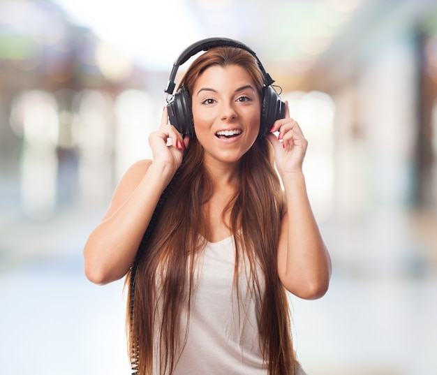 La muchacha alegre en los auriculares