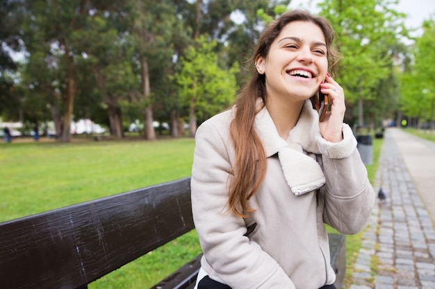 Foto gratuita muchacha alegre feliz que goza del teléfono divertido