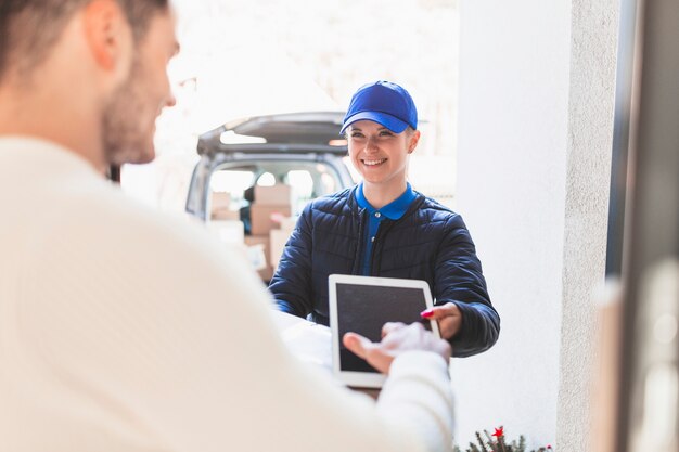 Muchacha alegre que entrega el paquete al cliente