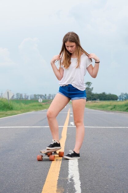 Muchacha bastante moderna que apuesta en la calle vacía