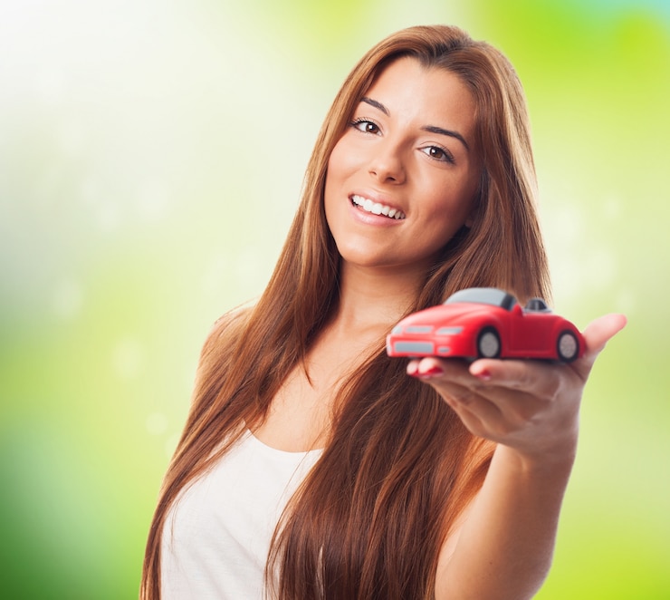 Foto gratuito muchacha bonita y coche de juguete de color rojo.