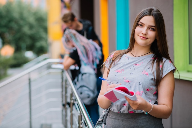 Muchacha bonita en el pórtico en la universidad