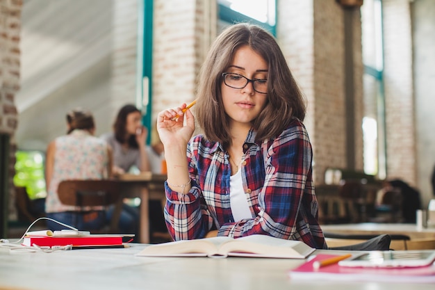 Foto gratuita muchacha bonita que lee el material educativo