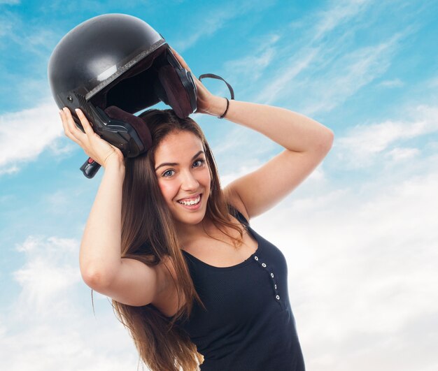 Muchacha con el casco de protección negro debajo de la cabeza.