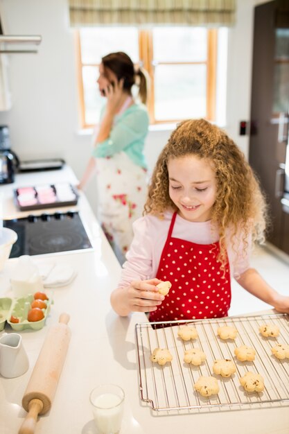 La muchacha come las galletas en la cocina