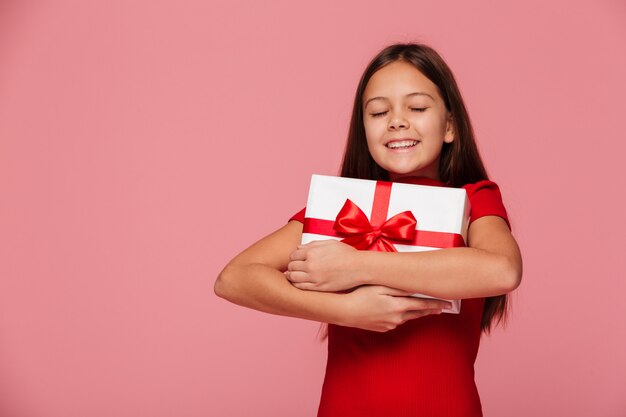 La muchacha feliz abraza su regalo y sonrisa aislada