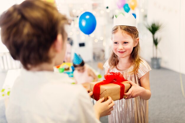 Muchacha feliz en regalo de toma de corona de papel