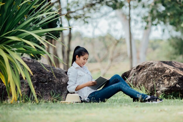 Muchacha hermosa en el bosque del otoño que lee un libro