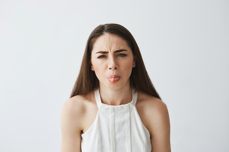Foto gratuito muchacha hermosa joven divertida que frunce el ceño mostrando la lengua.