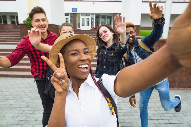 Muchacha negra que toma selfie con compañeros de clase