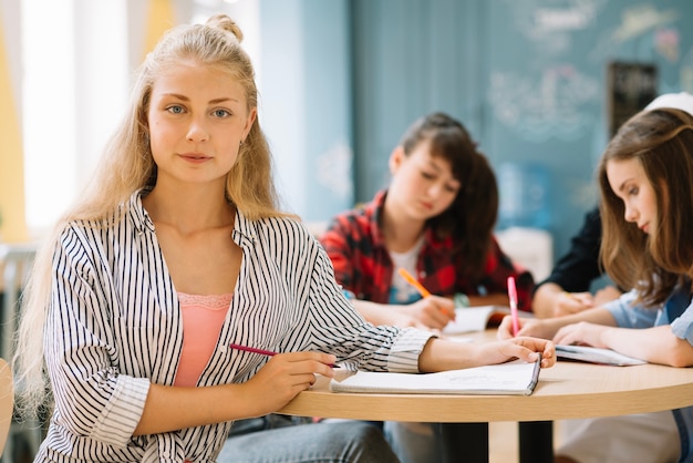 Foto gratuita muchacha que aprende con compañeros de clase