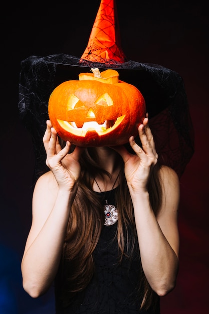 Muchacha que cubre la cara por la calabaza