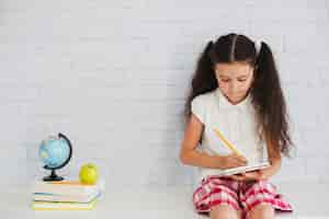 Foto gratuita muchacha que se inclina contra la escritura de la pared