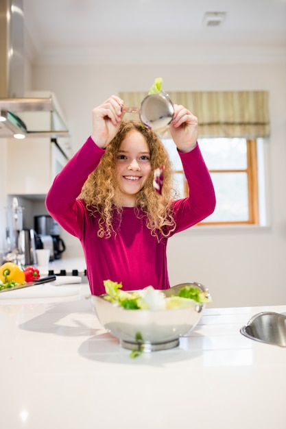 Muchacha que sostiene la lechuga en cuchara