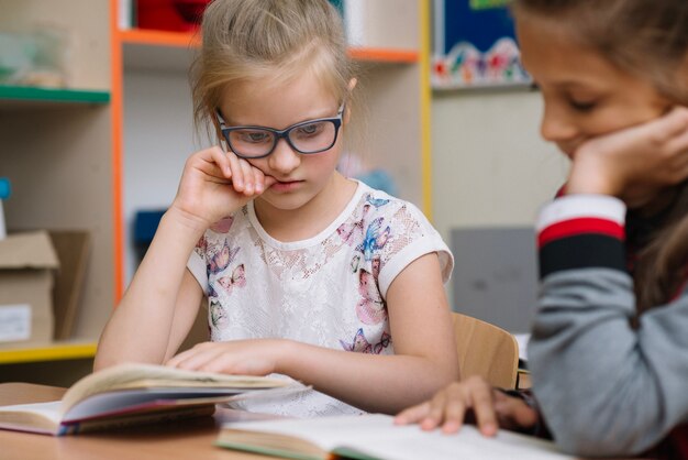 Muchacha rubia en la lectura de los vidrios