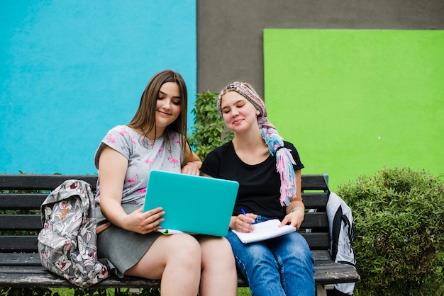 Muchachas que miran la computadora portátil felizmente