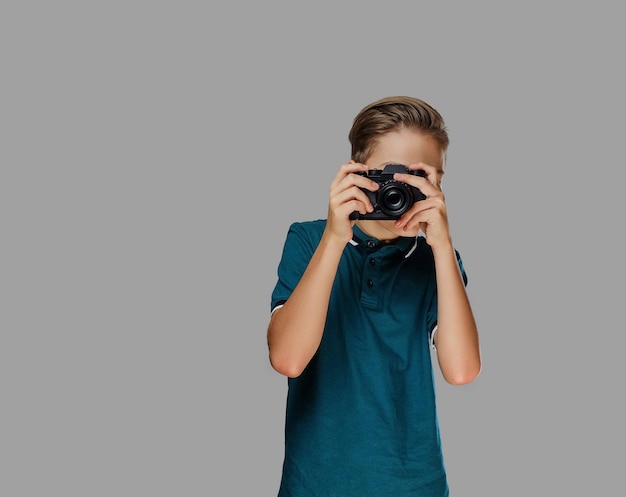 Muchacho adolescente tomando fotografías con una cámara profesional.