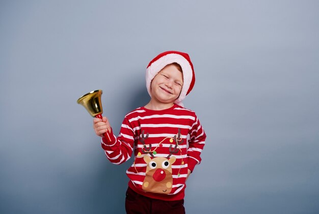 Foto gratuita muchacho alegre con campanilla en tiro de estudio