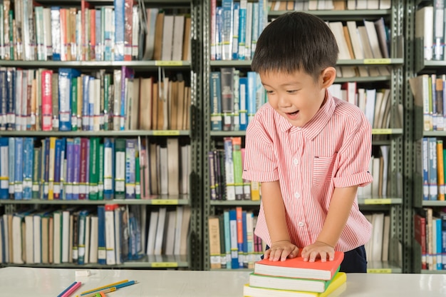 Muchacho asiático en la escuela de la sala de biblioteca