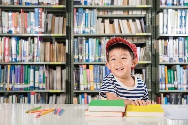 Muchacho asiático en la escuela de la sala de biblioteca