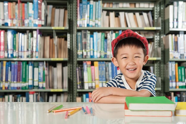 Muchacho asiático en la escuela de la sala de biblioteca