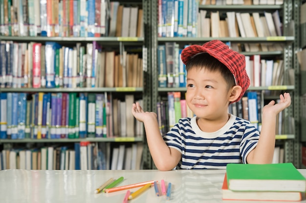 Muchacho asiático en la escuela de la sala de biblioteca