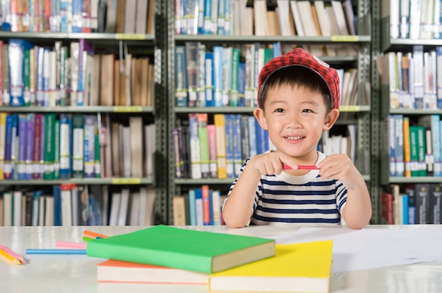 Muchacho asiático en la escuela de la sala de biblioteca