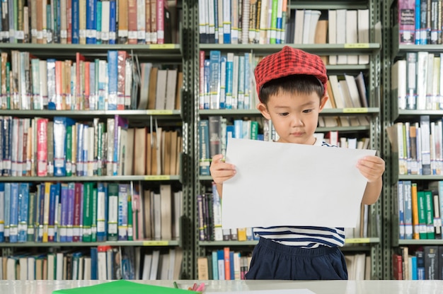 Muchacho asiático en la escuela de la sala de biblioteca