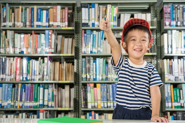 Muchacho asiático en la escuela de la sala de biblioteca