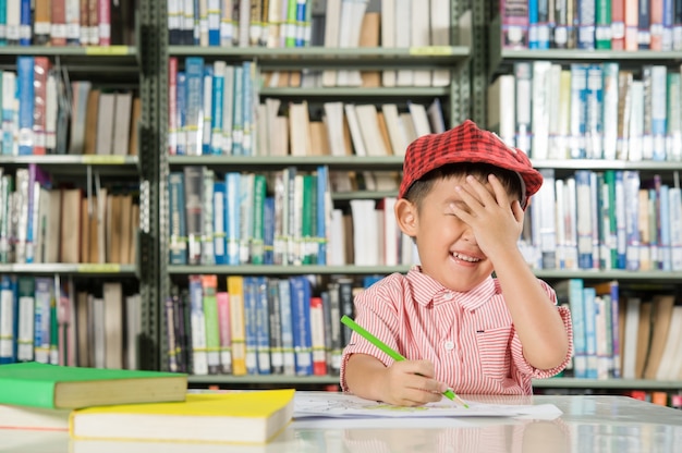 Muchacho asiático en la escuela de la sala de biblioteca