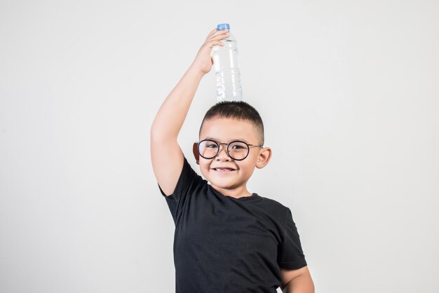 Muchacho divertido con la botella de agua en tiro del estudio