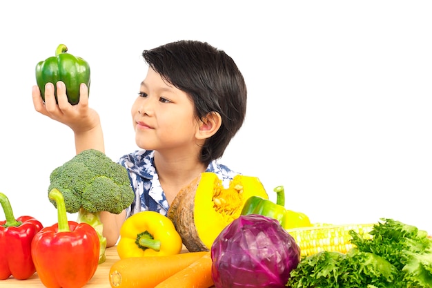 Muchacho sano asiático que muestra la expresión feliz con la verdura colorida fresca de la variedad