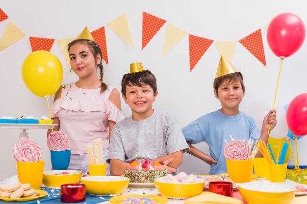 Muchacho sonriente del cumpleaños con sus amigos que disfrutan de la fiesta de cumpleaños